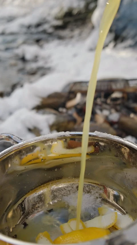 Unknown man pours orange juice to pan for cooking mulled wine at winter Stock Footage 300939923