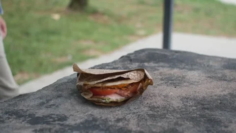 An unknown man put a panini on the table. A small street snack. Italian food Stock Footage 283924221