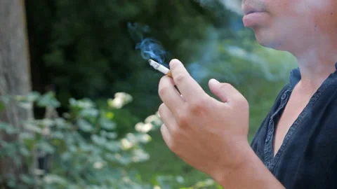 Unknown man smoking a cigarette. Cigarette smoke spread Stock Footage 97209964