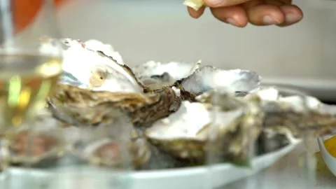 Unknown man squeezing lemon on seafood. Squeezing lemon juice onto the dish. Stock Footage 265839994