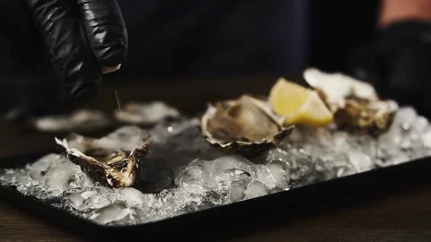 Unknown man squeezing lemon on seafood. Squeezing lemon juice onto the dish. Stock-Footage 336588741