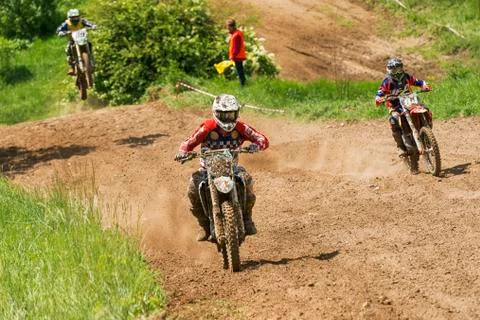 Unknown motorcycle racers overcomes motocross track Stock Photos