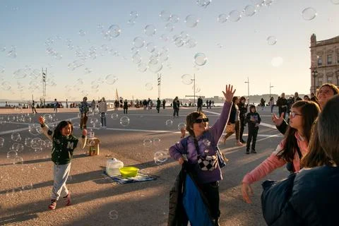 Unknown people playing with soap bubbles in the streets of Lisbon Stock Photos