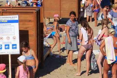 Unknown people standing in queue to dressing-room on a sandy beach on the Baltic Stock Photos