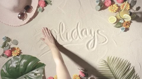 Unknown person erasing the word holidays with her hand written on a sandy bea Stock Footage 155112814