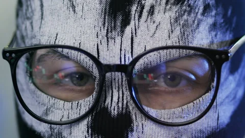 Unknown person looking at computer screen with charts reflected in glasses Stock Footage 202990526