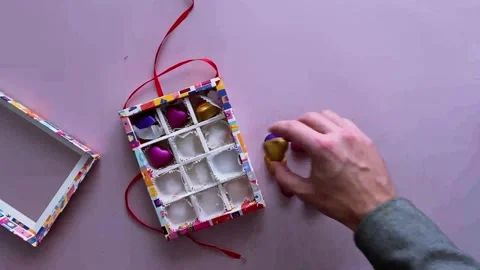 Unknown person puts heart-shaped chocolates in a festive box Stock Footage 256592609