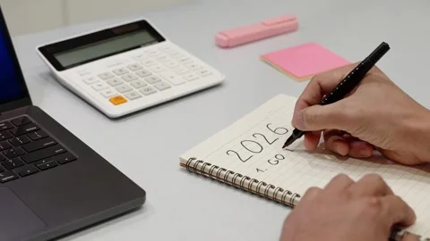 Unknown person writing down financial plans and 2026 goals in notepad Stock Footage 327033676