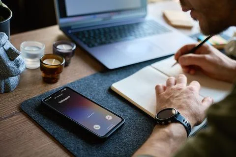Unknown phone call during work at desk with notebook Stock Photos