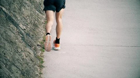 Unknown runner wearing orange running shoes, slow motion Stock Photos