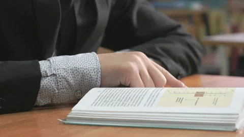 Unknown student dressed in suit reading book 스톡 동영상 87764827