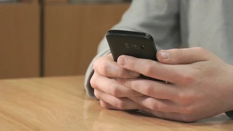 Unknown student holding black smartphone Stock Footage 82805728