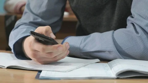 Unknown student holding black smartphone Stock Footage 82805812