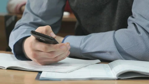 Unknown student holding black smartphone Stock Footage 87680666