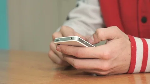 Unknown student holding silver-white smartphone Stock-Footage 82956993