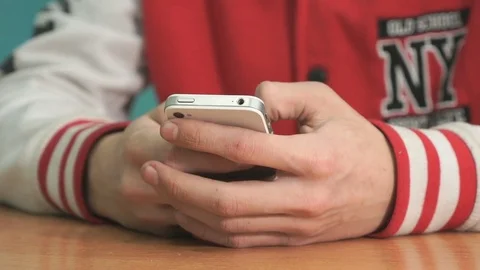 Unknown student holding silver-white smartphone Stock Footage 82957056