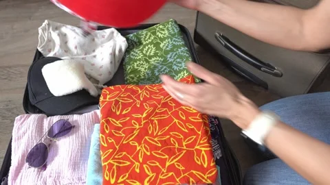 An unknown woman is packing a suitcase with things, close-up. Stock Footage 320523822
