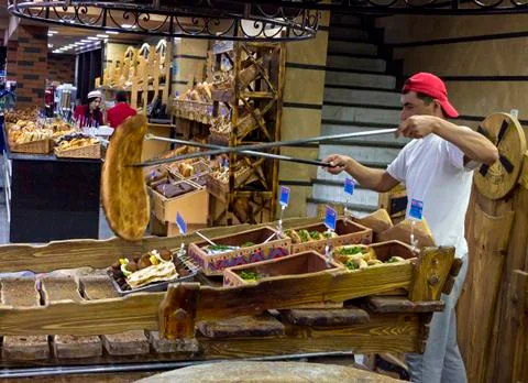 An unknown worker bakes bread Stock Photos