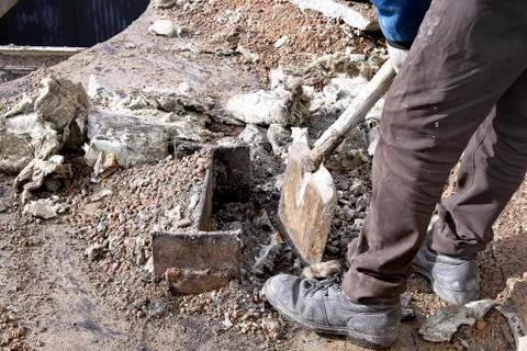 Unknown worker with a shovel clearing construction debris Stock Photos