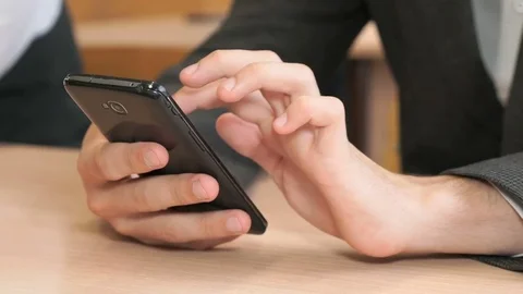 Unknown young man holding black smartphone Stock Footage 83103433