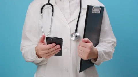 Unknown young woman doctor using mobile cell phone chatting browsing internet Stock Footage 256801202