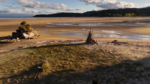 Unlit firepit on beach in Abel Tasman National Park, New Zealand. Aerial drone Stock Footage 336849571