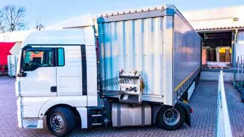 Unloading big container trucks at warehouse building Stock Photos