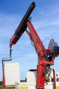 Unloading building blocks from a truck using a crane. Hydraulic manipulator. Stock Photos