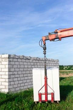 Unloading building blocks from a truck using a crane. Hydraulic manipulator. Stock Photos