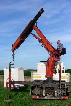 Unloading building blocks from a truck using a crane. Hydraulic manipulator. Stock Photos