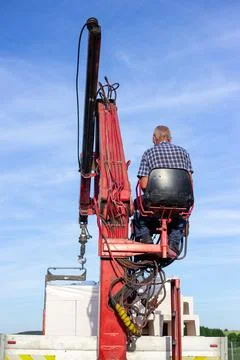 Unloading building blocks from a truck using a crane. Hydraulic manipulator. Stock Photos