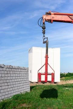 Unloading building blocks from a truck using a crane. Hydraulic manipulator. Stock Photos