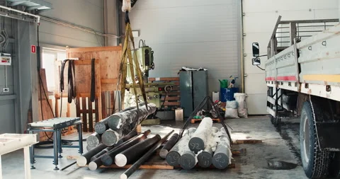 Unloading from a car using lifting machines to move metal pipes in a sheet metal Stock Footage 167025139