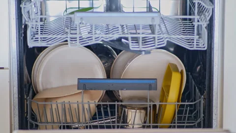 Unloading clean dishes from the dishwasher, stop motion. Removing cups, pots, Stock Footage 345981430