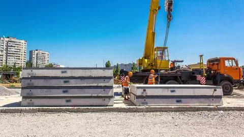 Unloading concrete plates by crane at road construction site timelapse. Stock Photos
