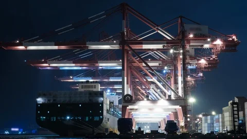 Unloading container to ship by industrial line gantry crane. 4K night time lapse Stock Footage 121993321