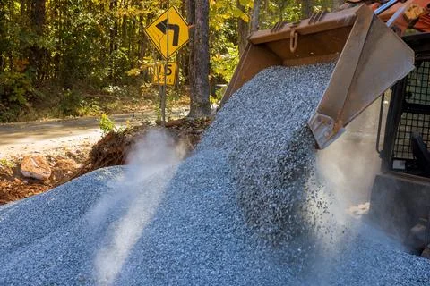 In unloading of crushed stone on the construction site during a road repair Stock Photos