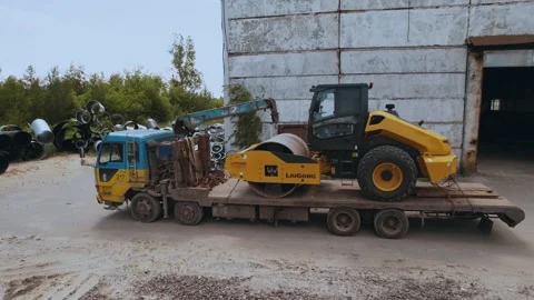 Unloading a dirt roller from a truck Stock Footage 201030976