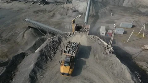 Unloading granite from the excavator into the crushing machine Stock Footage 200826578