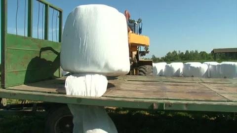 Unloading the hay stacks on the field. Loader working on the field. Vídeos de archivo 105760092