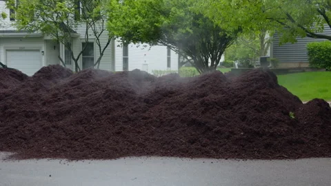 Unloading large pile of fresh mulch in residential neighborhood for landscaping Stock Footage 335958976