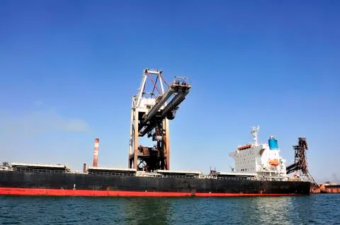 Unloading of an ore cargo liner Stock Photos