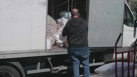 Unloading Packaged Linens onto Cart for Delivery Видео 284971492