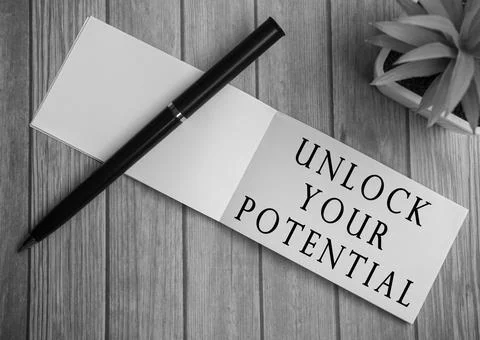 Unlock your potential text on notepad with potted plant on a wooden desk Stock Photos