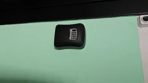 Unlocking a code safe with a keypad in a home setting Stock Footage 340549655
