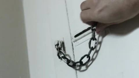 Unlocking door with chain lock, removing chain from door, hotel security, 4K Stock Footage 340232528