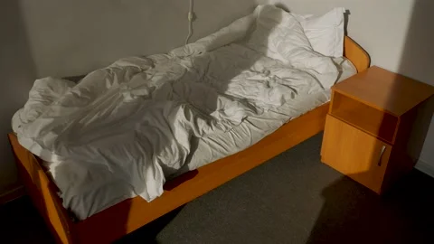 Unmade Bed in bright sunlight. Shadow of a man closes the window curtain 2 Stock Footage 166505139
