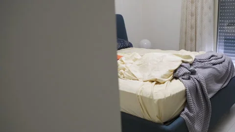 Unmade bed with rumpled sheets and blankets in bedroom Video stock 336127483