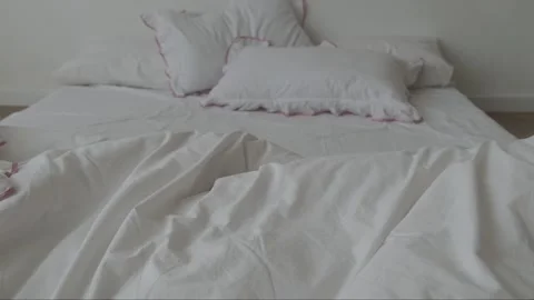 Unmade bed with white sheets. Unmade empty bed. Close-up messy white bedroom in Stock Footage 311447763