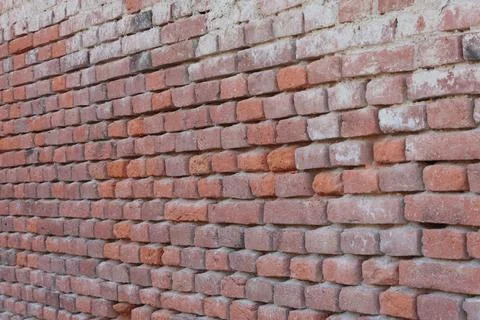 Unmaintained old brick wall made only of bricks without plaster Stock Photos